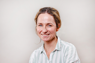 Frau mit hellen Haaren und heller Bluse