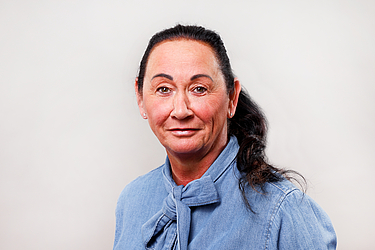 Frau mit dunklen haaren und blauer Bluse