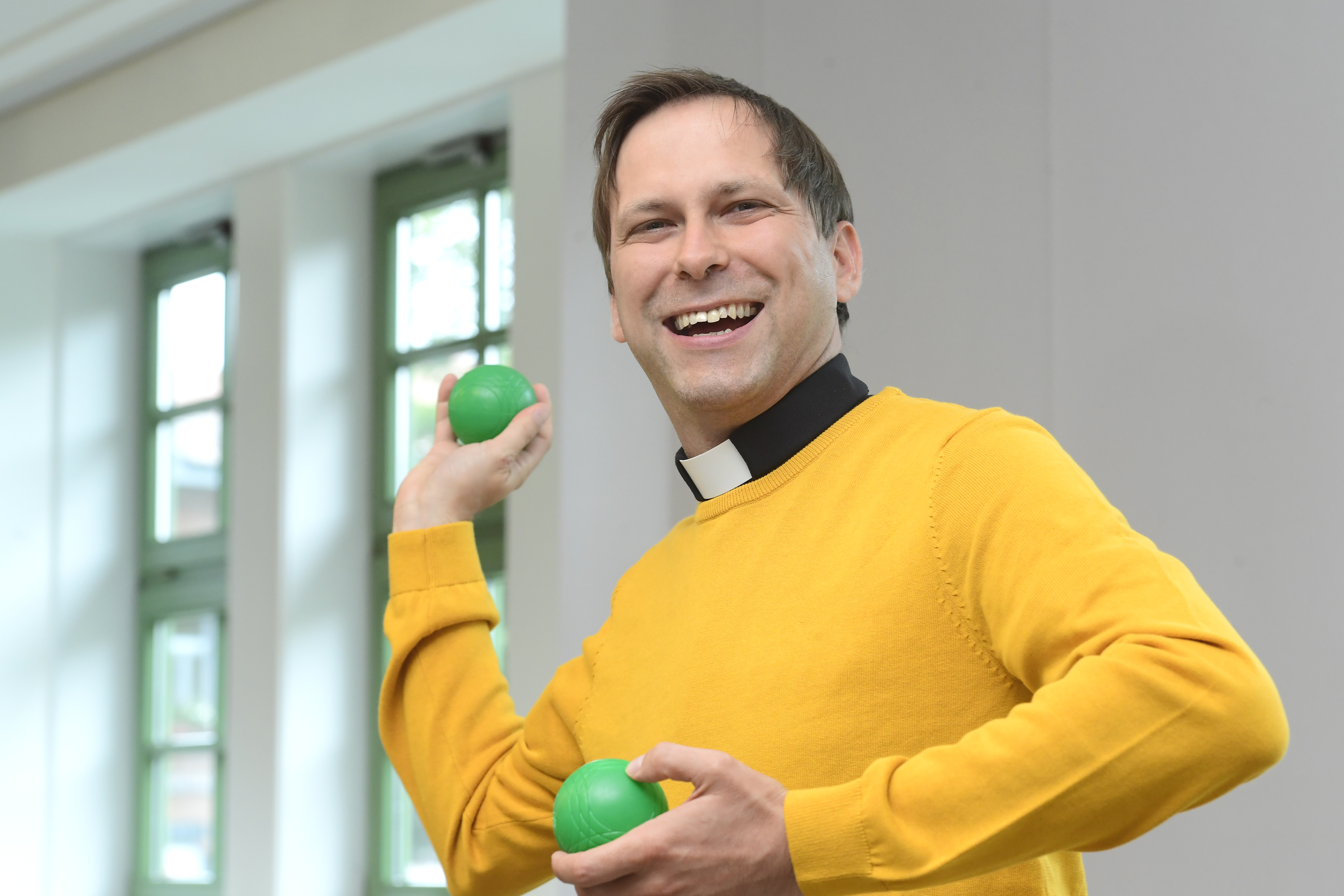 	Mann mit farbigen Bällen in der Hand