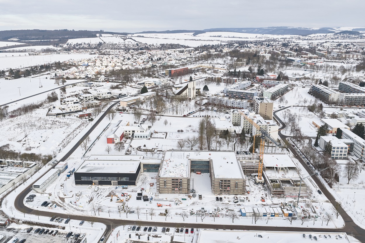 	Schulgebäude in gesamter Breite mit Landschaft im Hintergrund im Schnee