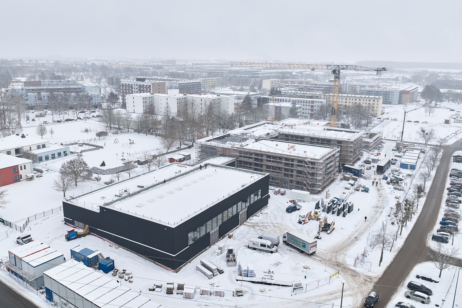 	Schule von oben mit Baugerüst im Schnee
