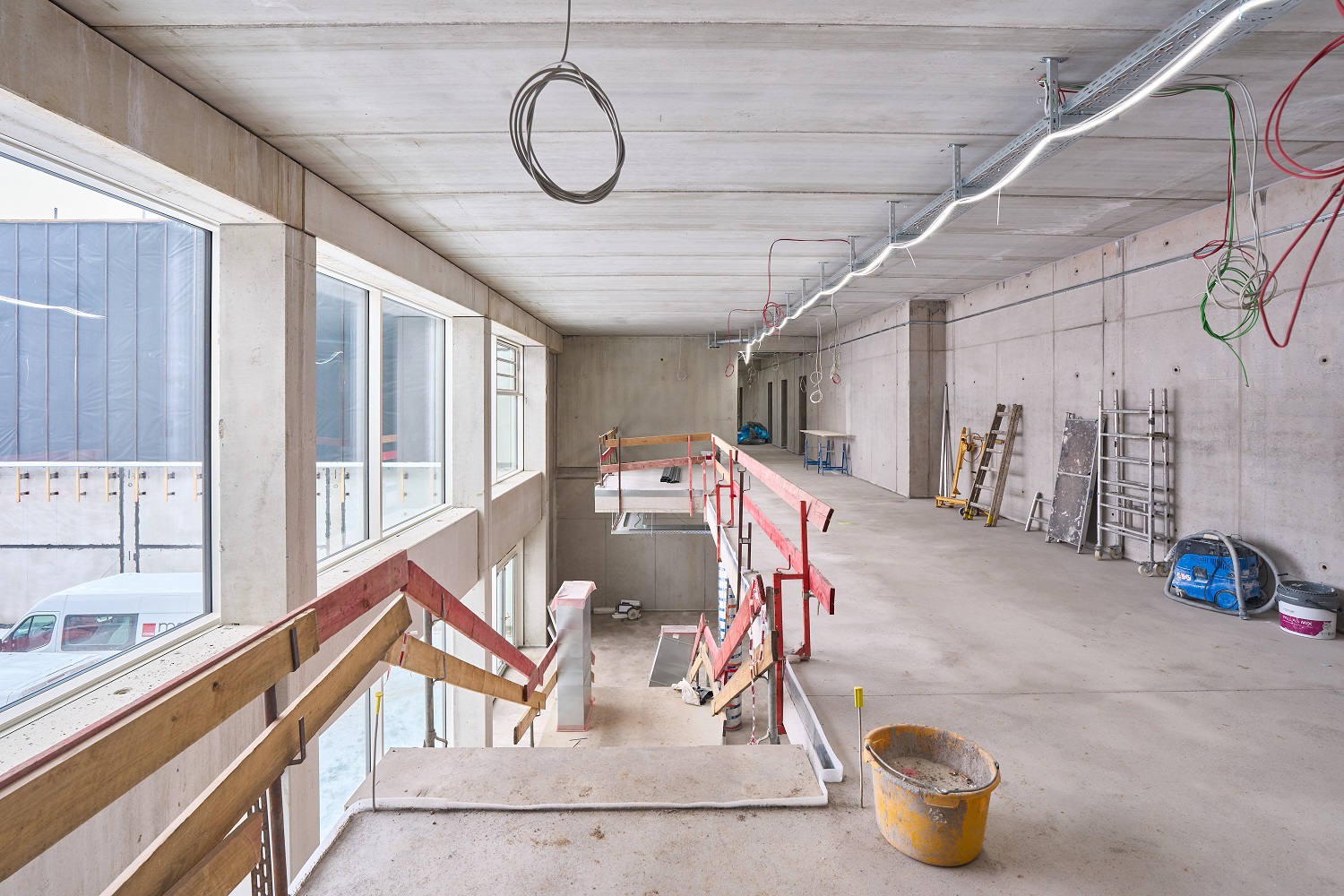 	Treppe mit Holzgeländer, verputze Wände, Kabel von der Decke