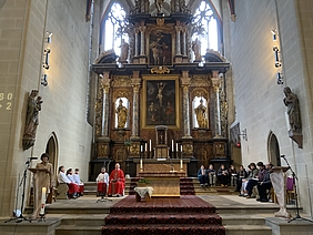Personen im Altarraum einer Kirche