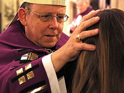 Bischof, der eine junge Frau segnet