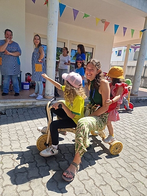 Frau mit 2 Mädchen auf einem Dreirad