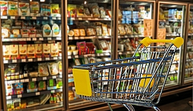 Einklaufskorb vor vollen Regalen im Supermarkt