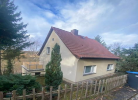 Einfamilienhaus mit rotem Dach und Zaun