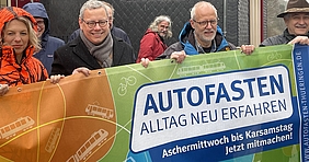Personen mit Banner: Autofasten