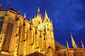 Beleuchtete gotische Kathedrale vor dunkelblauem Abendhimmel