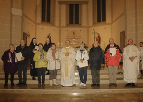 Menschengruppe mit Bischof im Altarraum in einer Kirche