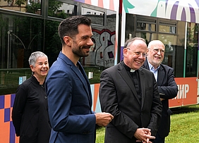 Vier Personen vor einer Straßenbahn