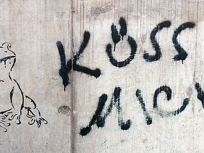 Graffito an einer Mauer (Frosch und Aufschrift "Küss mich")