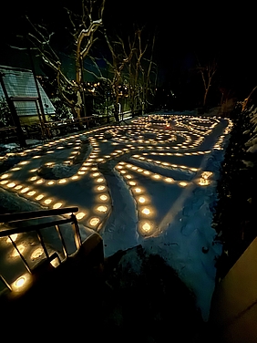 brennende Kerzen im Dunkeln, die ein Labyrinth bilden