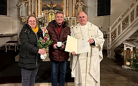 Drei Personen im Altarraum einer Kirche