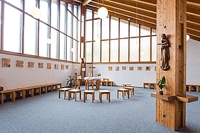 Kapelle von innen, große Fenster, Holzbalken, Holzstühle