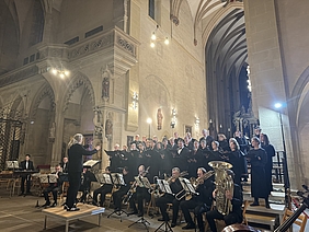 Chor mit Orchester und Dirigent auf einem Podest