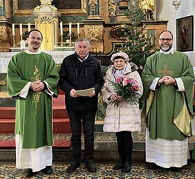 Vier Personen im Altarraum einer Kirche