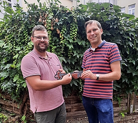 zwei junge Männer - Schlüsselübergabe